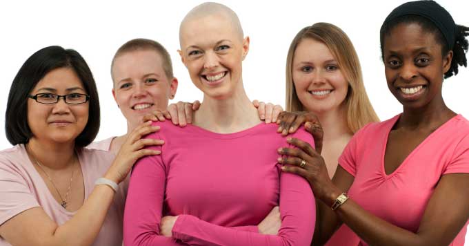 women holding and supporting a breast cancer survivor